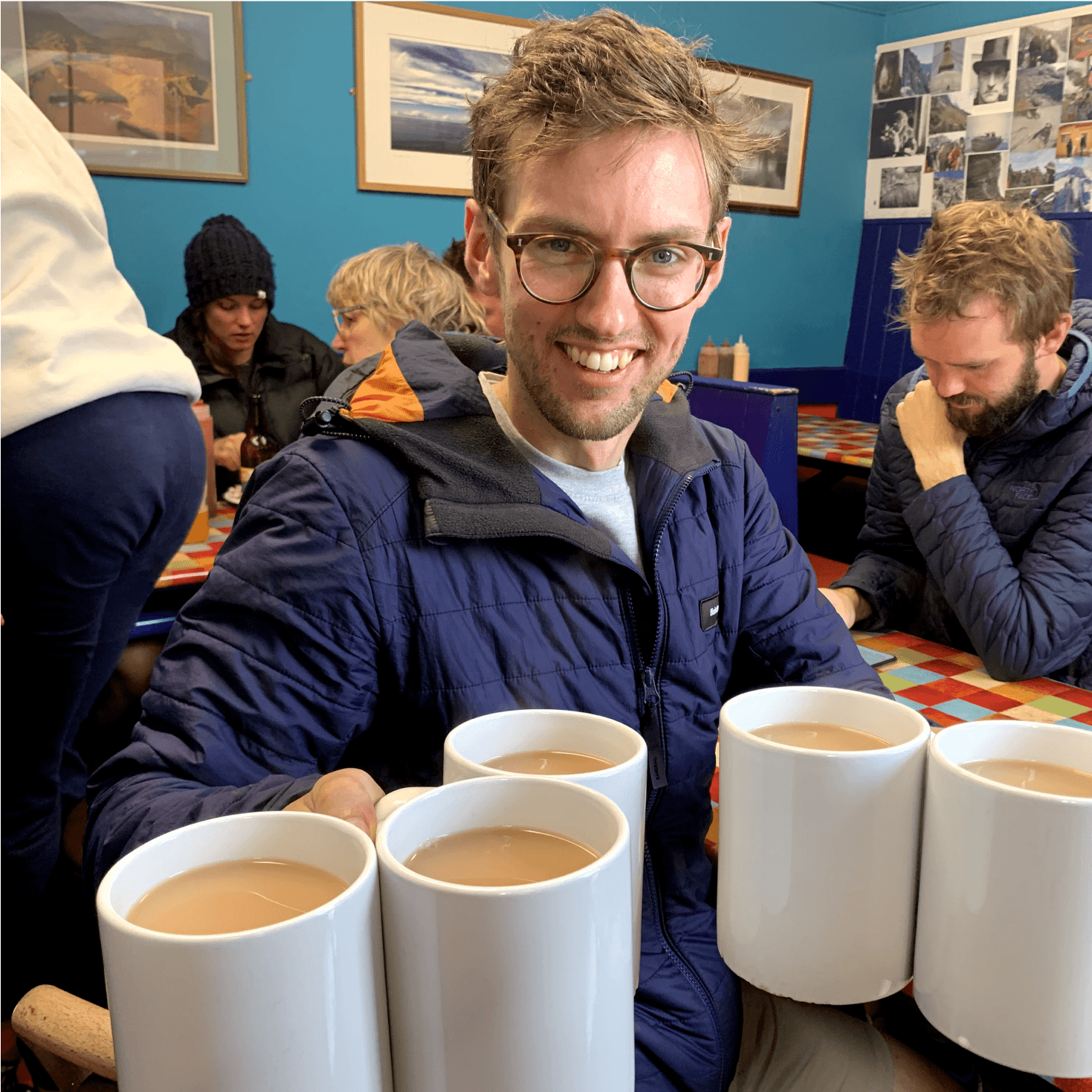 Member of the team with six mugs of coffee