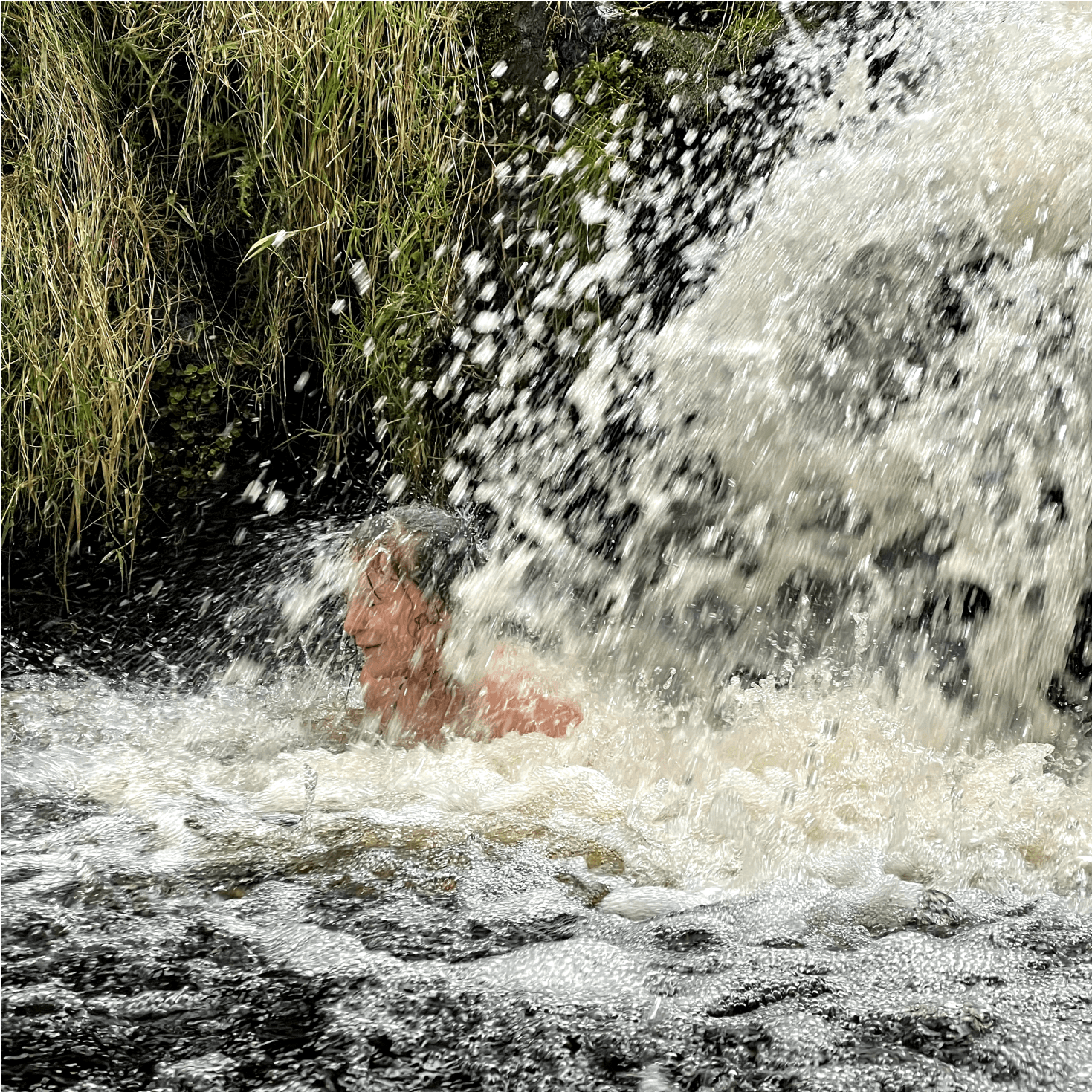 Member of the team inside a waterfall